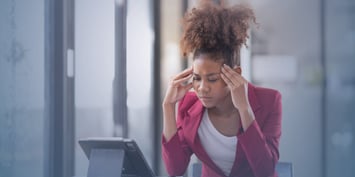 Frustrated young professional reviewing job descriptions on a digital tablet in an office