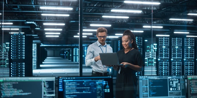 IT professionals reviewing data in a modern server room.