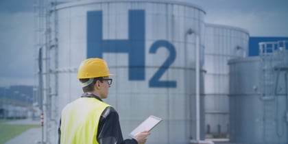 Engineer in safety gear at a green hydrogen facility, illustrating skills gaps holding back green hydrogen projects and the need to close workforce shortages.