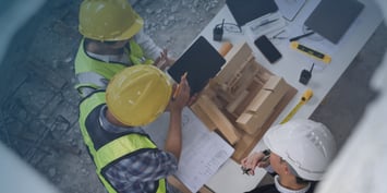 Contractors talk over a construction project on a table.